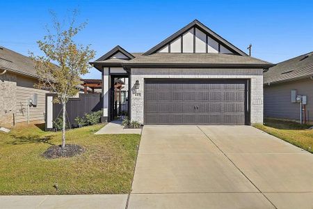 View of front facade featuring a front yard and a garage