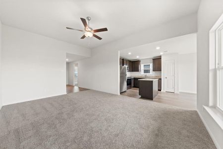 Unfurnished living room featuring ceiling fan, light hardwood / wood-style floors, and sink