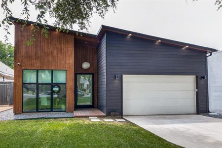 View of front of house with a garage and a front lawn