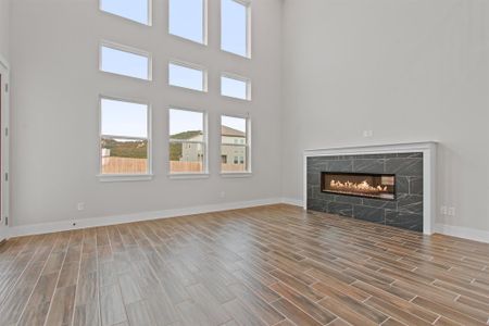 Unfurnished living room featuring a towering ceiling and a premium fireplace