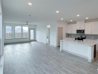 Kitchen featuring light wood-type flooring, stainless steel appliances, a sink, and light countertops