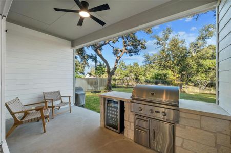 Your living space extend outdoors onto this fabulous entertainers covered back porch with an outdoor kitchen including a built-in grill and peaceful greenbelt views.