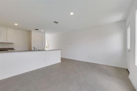 Unfurnished living room with tile patterned flooring and sink