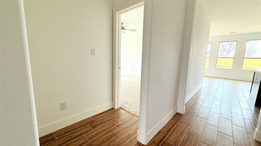 Hallway with baseboards and wood finish floors