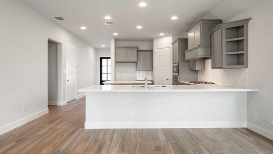 Kitchen featuring light hardwood / wood-style floors, stainless steel gas cooktop, decorative backsplash, sink, and gray cabinetry