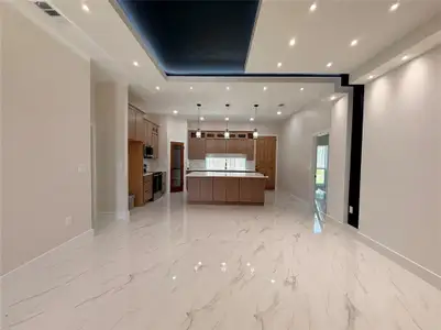 Kitchen with appliances with stainless steel finishes, baseboards, light countertops, open floor plan, and recessed lighting Kitchen with appliances with stainless steel finishes, baseboards, light countertops, open floor plan, and recessed lighting