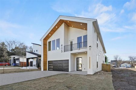 Contemporary home featuring a balcony, an attached garage, concrete driveway, and stucco siding