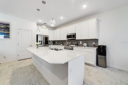 The home chef will appreciate the sleek quality of the kitchen featuring a stylish color palette, stone counters, pendant lighting, STAINLESS STEEL APPLIANCES and a walk-in pantry for ample storage.