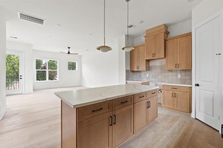 Kitchen features white quartz countertops, Zellige mosaice tile on the backsplash, and stainless steel appliances