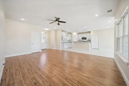 Unfurnished living room with ceiling fan and light hardwood / wood-style flooring