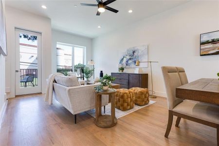 Living room with ceiling fan and light hardwood / wood-style flooring