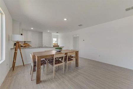 Dining area with sink and light wood-type flooring