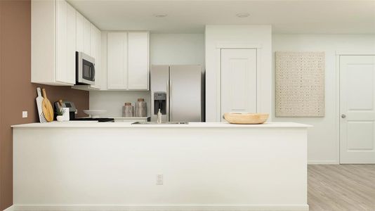 Kitchen with stainless steel appliances, kitchen peninsula, light hardwood / wood-style floors, and white cabinets