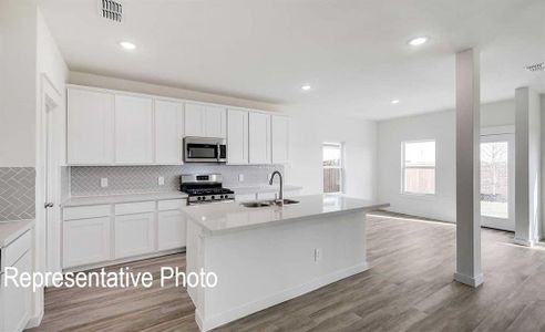 Kitchen featuring white cabinets, stainless steel appliances, sink, and light hardwood / wood-style floors