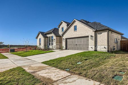 View of front facade featuring a garage and a front lawn