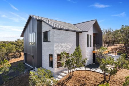 View of home's exterior with metal roof, brick siding, and a standing seam roof