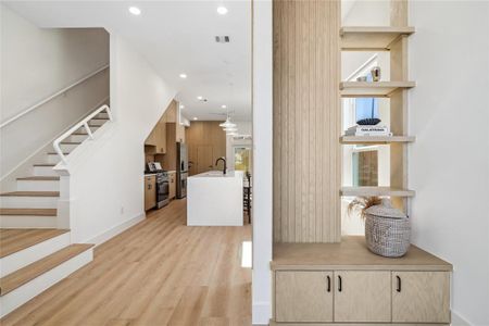 Step into style with this thoughtfully designed entryway featuring custom built-in storage and shelving. A seamless introduction to the home's stunning open-concept first floor, this space blends functionality with modern elegance.