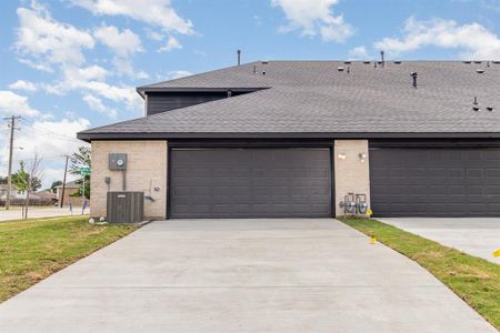 View of front of house featuring a garage and central AC unit