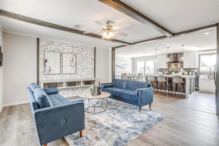 Living room with beamed ceiling, light hardwood / wood-style floors, and ceiling fan