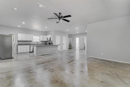 Unfurnished living room with sink, a wealth of natural light, and ceiling fan