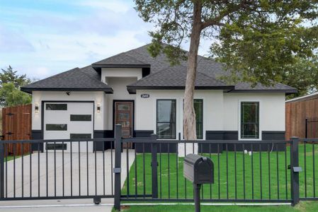 View of front of property featuring a large lawn and a one car garage with a gate