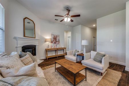 Living room featuring ceiling fan and wood like tile flooring.