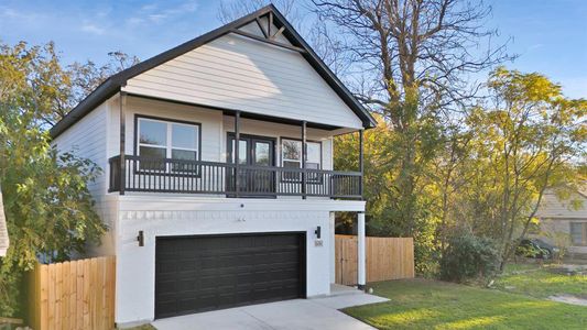 View of front of house featuring a garage, a balcony, and a front yard