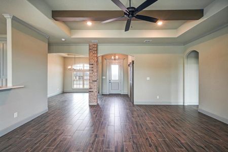 Front entry with accent brick pillar, wood look tile, and formal dining.