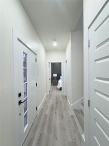 Hallway with light hardwood / wood-style flooring