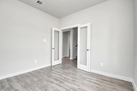 Another view of the home office, with French doors,  at the forefront of the home. Sample photo of completed home with similar floor plan. Actual colors and selections may vary.