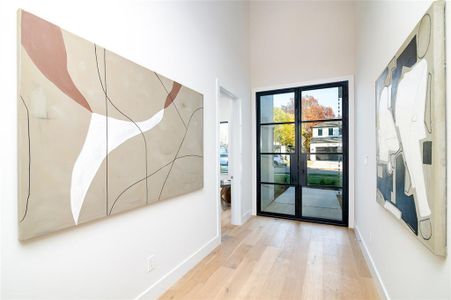 Entryway featuring french doors, light hardwood / wood-style floors, and a high ceiling