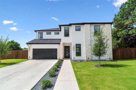 View of front of house featuring a garage and a front lawn