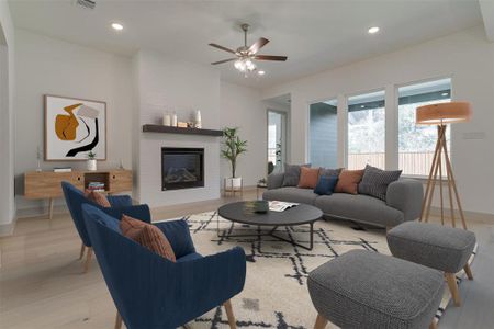 Living room featuring a fireplace, light wood-type flooring, and ceiling fan