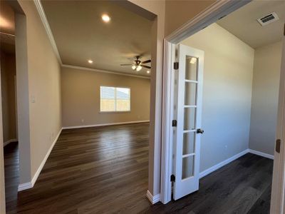 Unfurnished room with crown molding, ceiling fan, and dark wood-type flooring