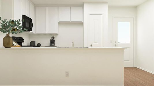 Kitchen with black appliances, sink, light wood-type flooring, and white cabinets