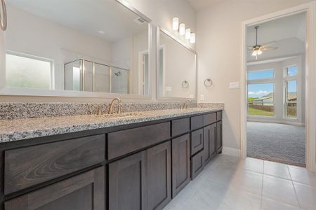 Bathroom featuring ceiling fan, vanity, tile patterned flooring, and an enclosed shower