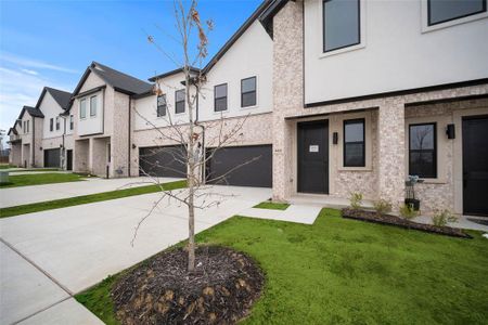 View of front of house with stucco siding, a front lawn, a residential view, concrete driveway, and a garage