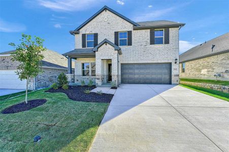 View of front of home featuring a front yard and a garage