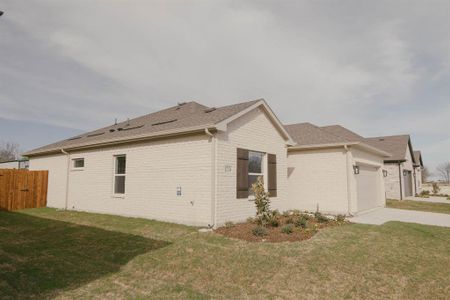 View of side of home featuring a garage and a lawn