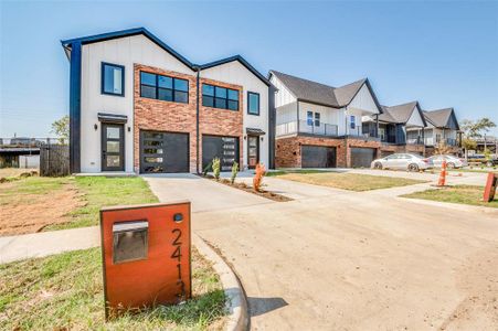 View of front of home featuring a garage and a balcony