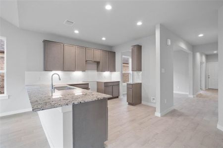 This kitchen is by far any chef’s dream! This spacious kitchen features high ceilings, stained wood cabinets, granite countertops, SS appliances, modern tile backsplash, recessed lighting, extended counter space for breakfast bar, and a walk-in pantry all overlooking your huge family room.