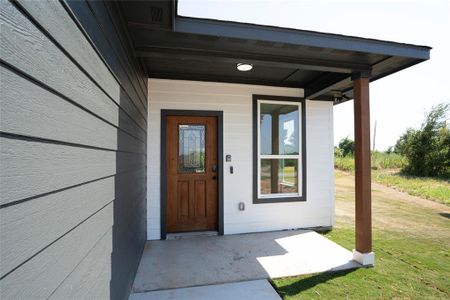 View of exterior entry featuring a yard