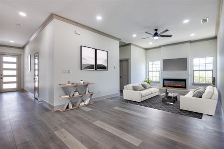 Living room with ceiling fan, crown molding, and dark hardwood / wood-style floors