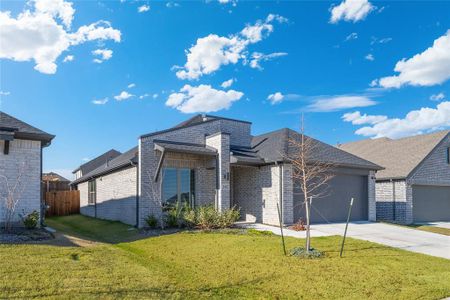 View of front facade featuring a front yard and a garage