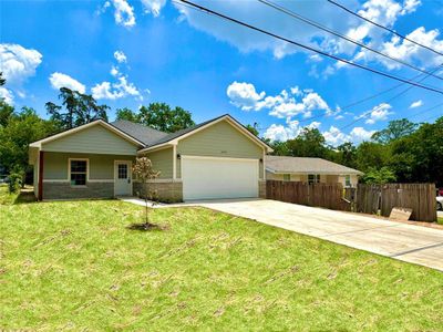 Ranch-style home featuring a front yard and a garage