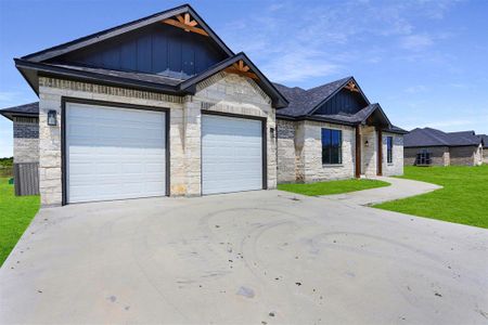 Craftsman inspired home featuring a garage and a front lawn