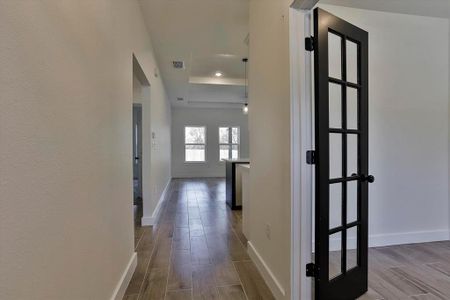 Hallway with hardwood / wood-style floors