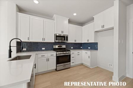 Neutral color cabinets paired with a striking backsplash and modern stainless steel create the kitchen of your dreams!  REPRESENTATIVE PHOTO