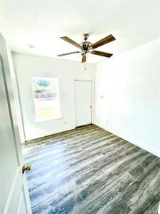 Empty room with wood-type flooring and ceiling fan