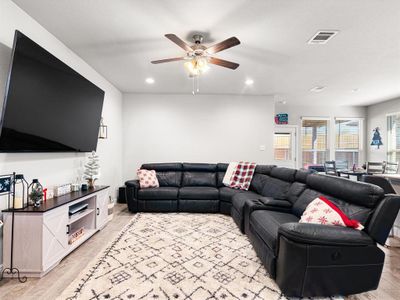 Living room with ceiling fan and light wood-type flooring